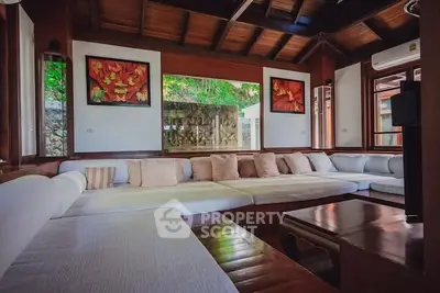 Spacious living room with cozy seating and wooden accents in a luxurious home.