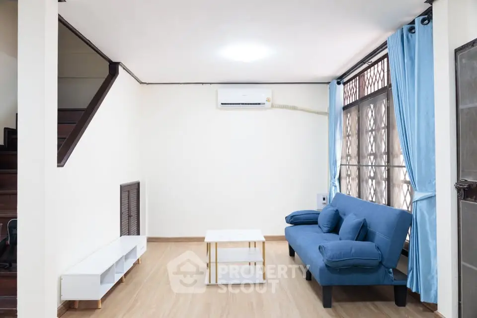 Spacious living room with modern blue sofa and natural light