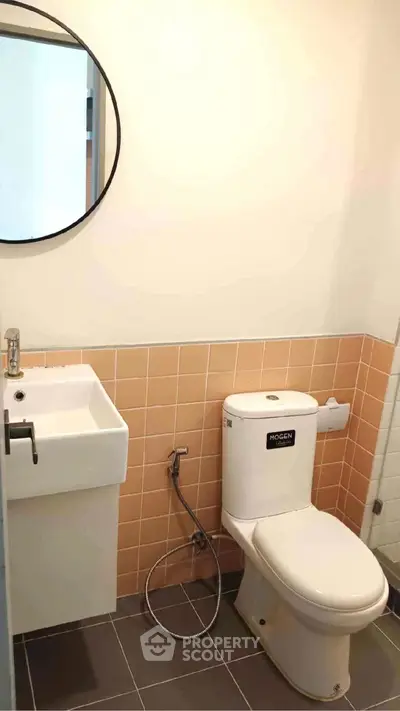 Modern bathroom with round mirror and compact sink