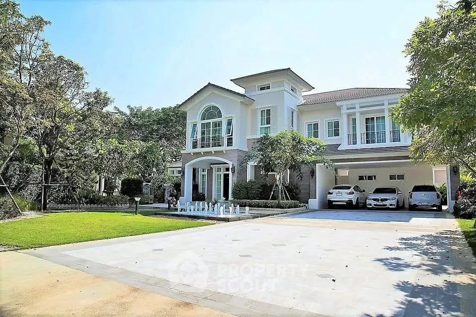 Luxurious modern house with spacious driveway and lush garden, featuring elegant architecture and ample parking space.