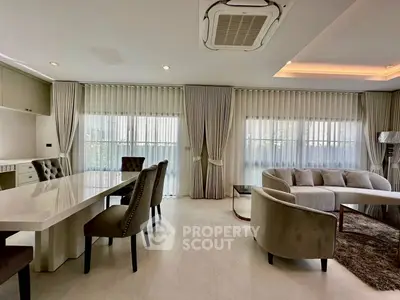 Luxurious living room with elegant dining area and plush seating, featuring floor-to-ceiling windows and modern decor.