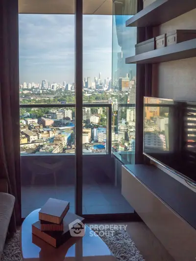 Modern living room with city view from balcony, featuring sleek furniture and large glass doors.