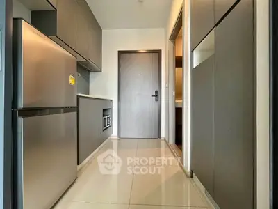Modern kitchen with sleek cabinetry and stainless steel appliances in a contemporary apartment.