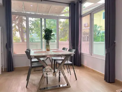 Bright dining area with large windows and modern table, perfect for family gatherings.