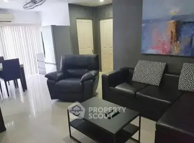 Modern living room with sleek black furniture and abstract art, perfect for stylish urban living.