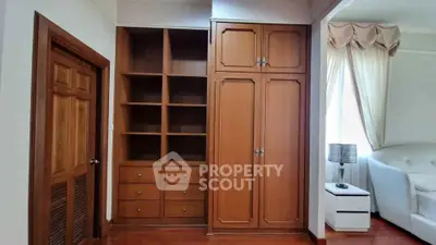 Spacious bedroom with elegant wooden wardrobe and cozy lighting