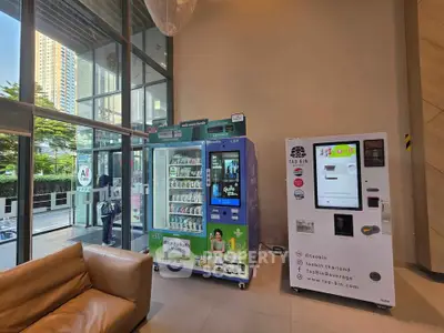 Modern building lobby with vending machines and street view, showcasing convenience and urban lifestyle.