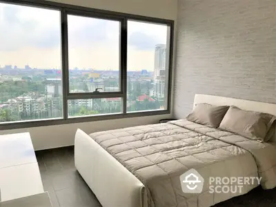 Spacious bedroom with large windows offering panoramic city views, modern design, and ample natural light, perfect for relaxation and comfort.