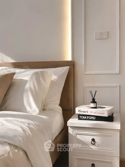 Elegant bedroom with stylish decor and natural light, featuring a cozy bed and chic nightstand.
