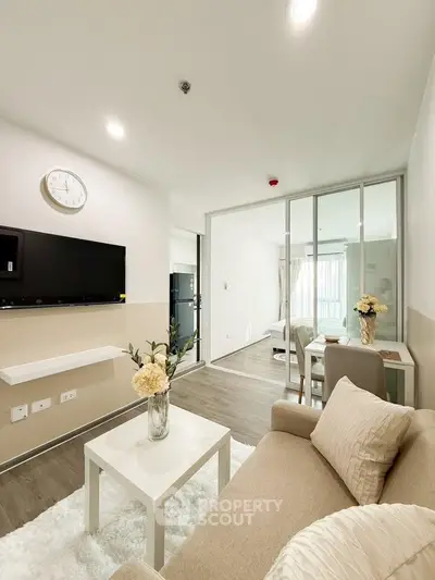 Modern living room with elegant decor and sliding glass doors leading to a bright bedroom.