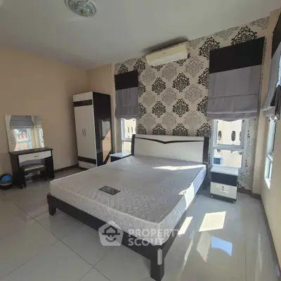 Spacious bedroom with elegant decor and ample natural light, featuring a stylish bed and modern furnishings.