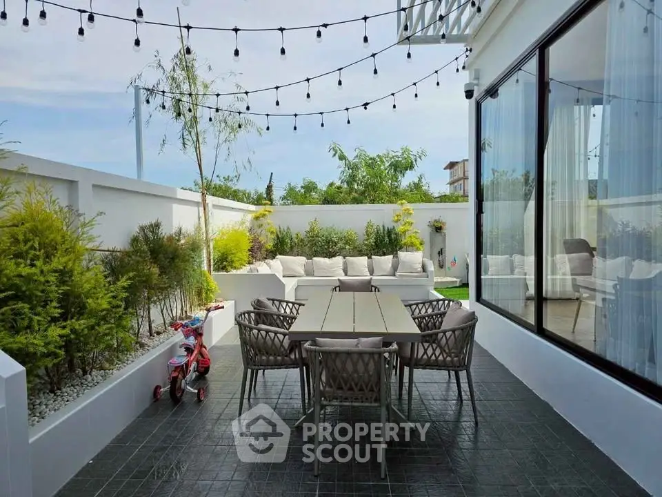 Charming outdoor patio with modern furniture and lush greenery, perfect for relaxation and entertaining.