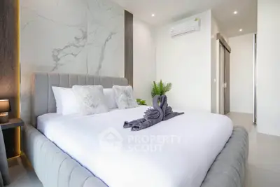 Luxurious modern bedroom with elegant decor and plush bedding in a stylish apartment.