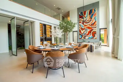 Luxurious modern dining room with high ceilings and artistic decor in a spacious open-plan layout.