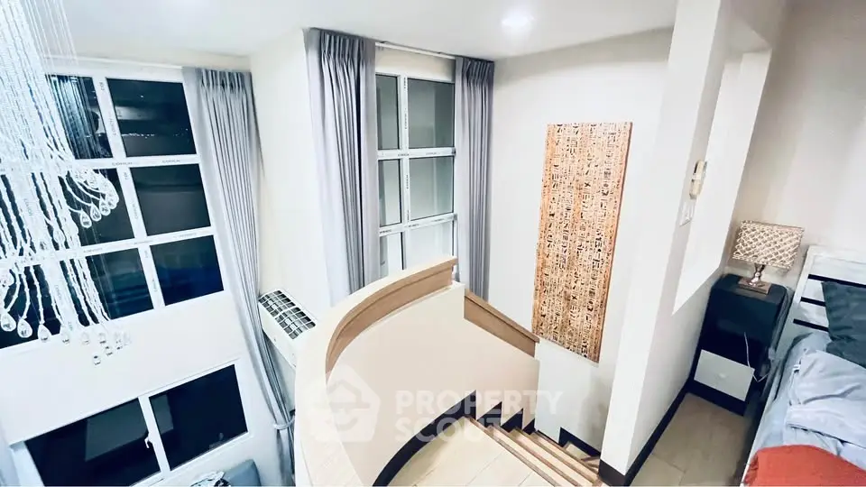 Modern duplex interior with elegant staircase and large windows