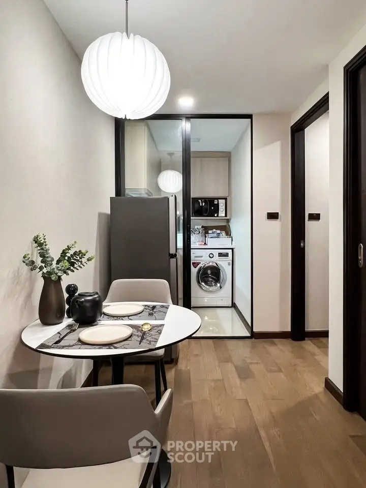 Modern kitchen with dining area and built-in appliances in sleek apartment