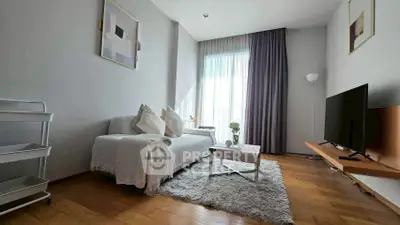 Modern living room with cozy sofa, TV, and natural light through large window.