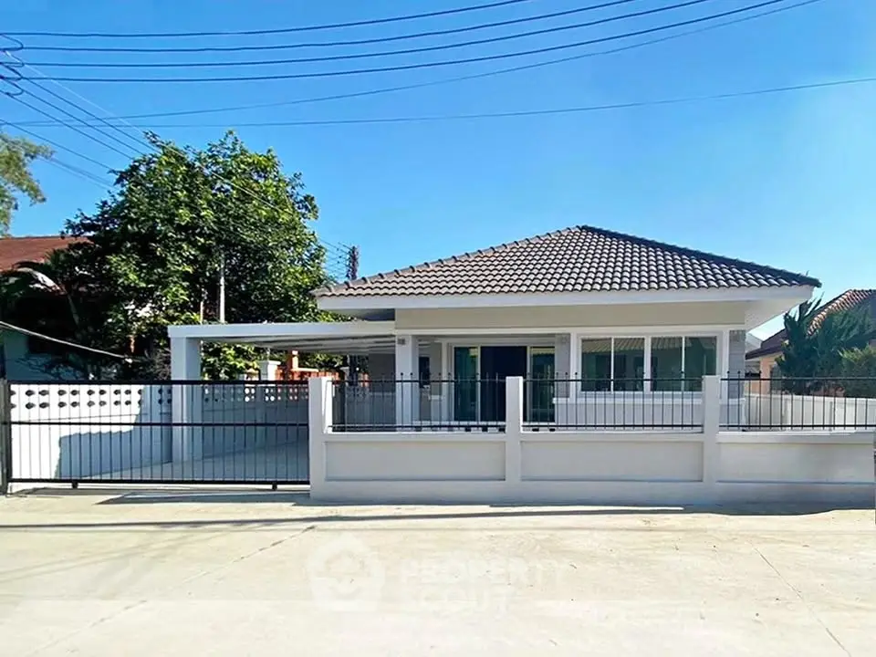 Charming single-story house with tiled roof and gated driveway in sunny neighborhood.