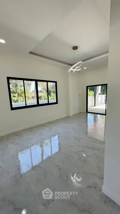 Spacious modern living room with large windows and elegant lighting