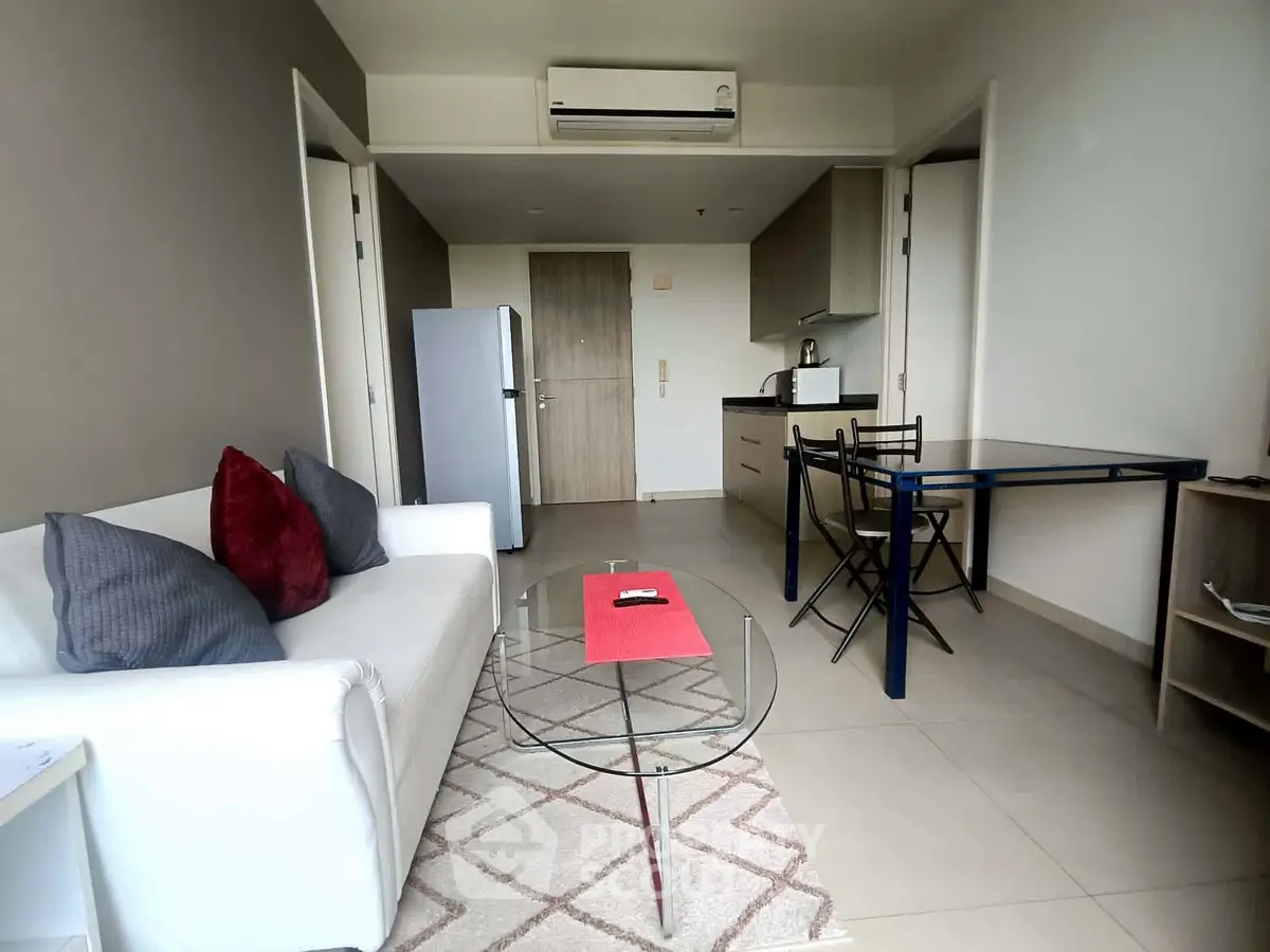 Modern living room with stylish furniture and open kitchen layout in a cozy apartment.