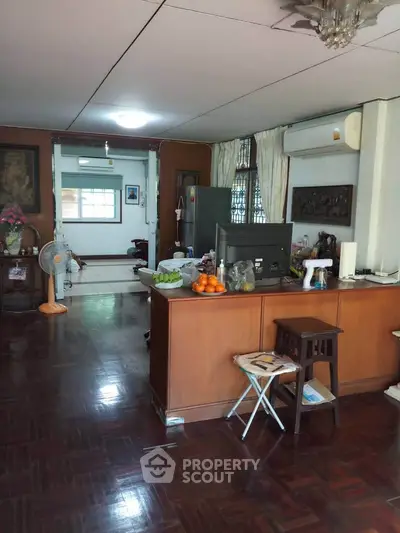 Spacious living room with wooden flooring and modern decor, featuring a cozy open layout and natural light.