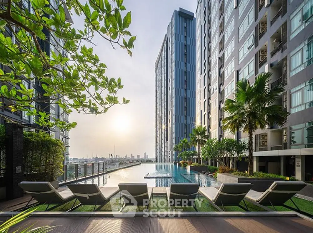 Luxurious high-rise building with stunning rooftop pool and city view at sunset.