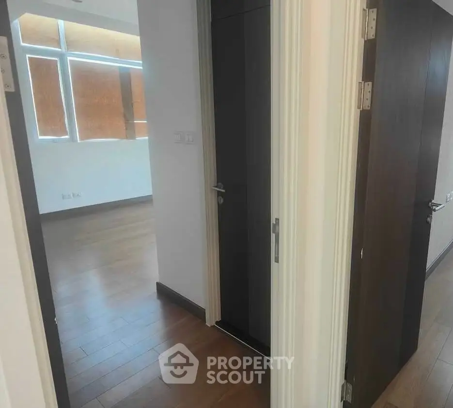 Spacious modern apartment with wooden flooring and ample natural light.