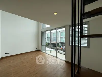 Spacious modern living room with large windows and wooden flooring