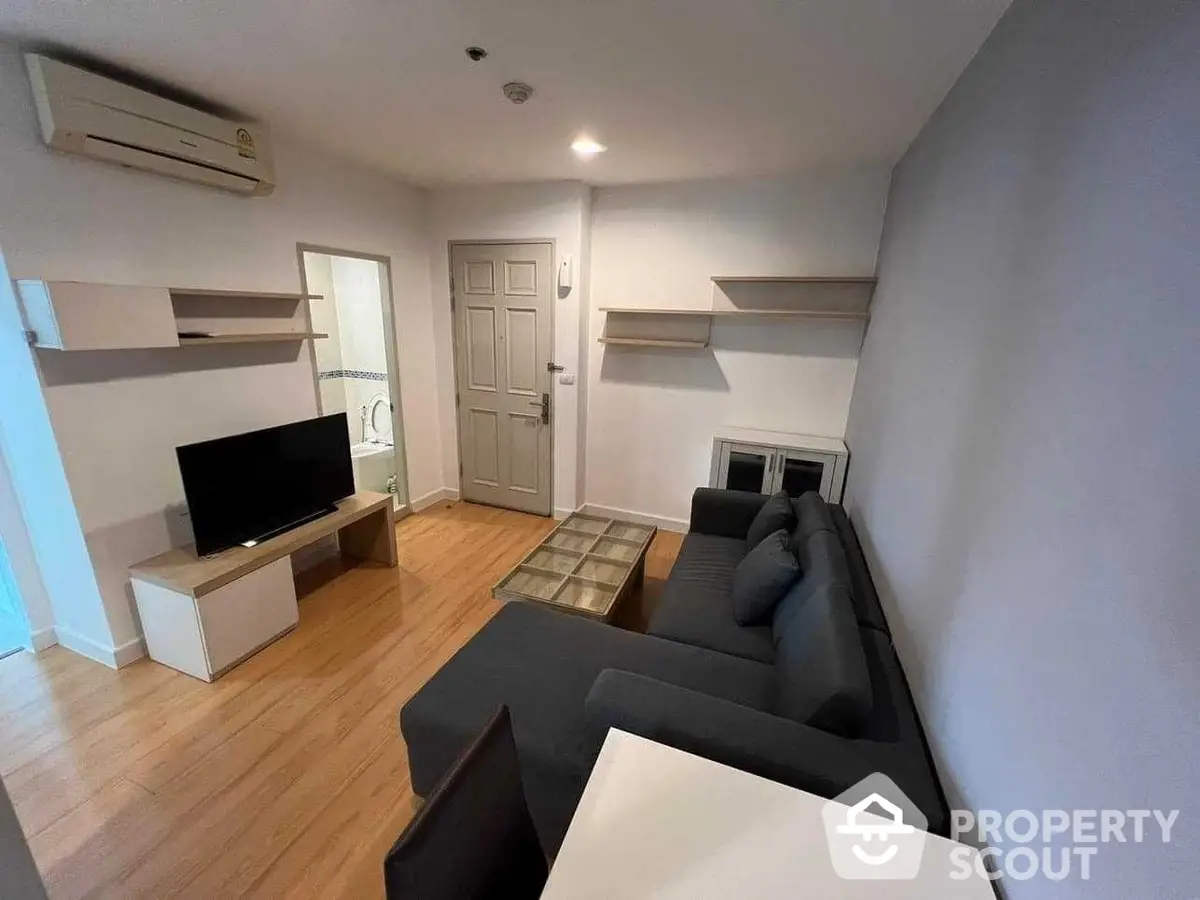 Modern minimalist living room with sleek furniture and wooden flooring, featuring a cozy sofa and wall-mounted shelves, perfect for urban living.