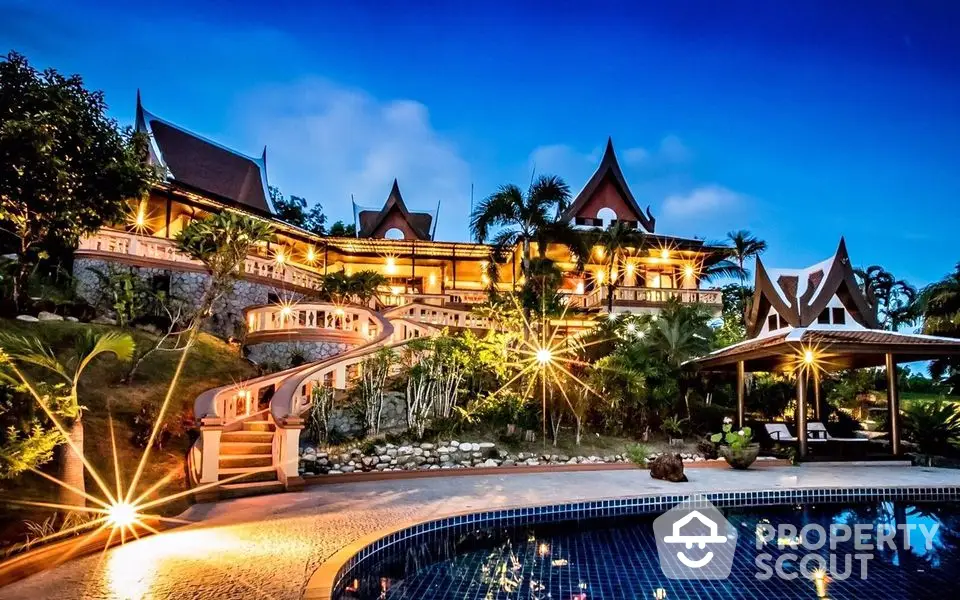 Luxurious Thai-style villa with stunning pool and lush garden at dusk.