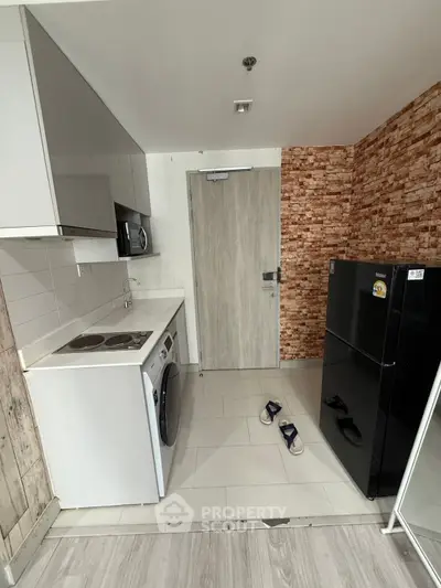 Modern kitchen with sleek appliances and stylish brick accent wall