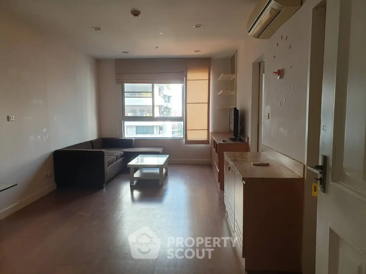 Spacious living room with modern furniture and large window for natural light.