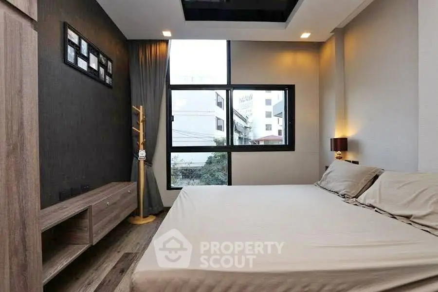Modern bedroom with large window and stylish decor in urban apartment