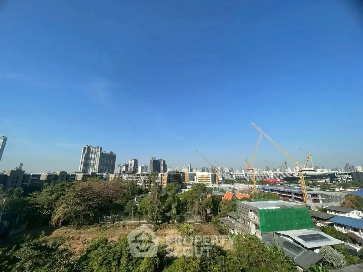Stunning cityscape view with construction cranes and clear blue sky.