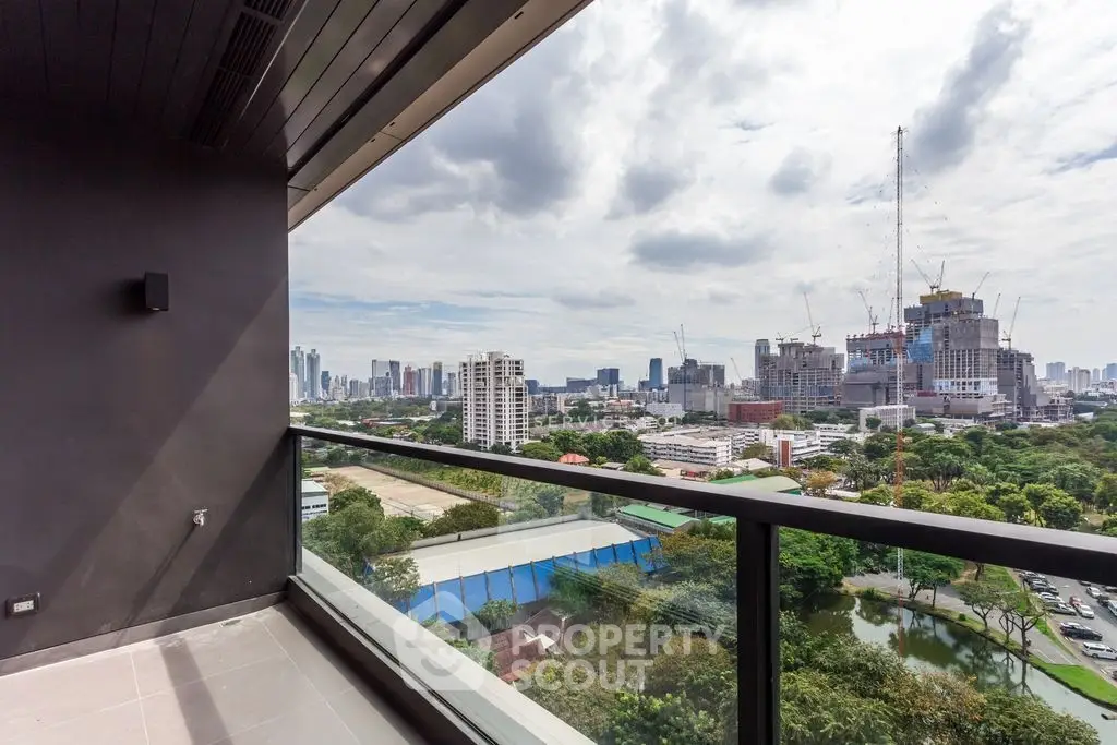 Stunning cityscape view from a modern balcony with glass railing, perfect for urban living.