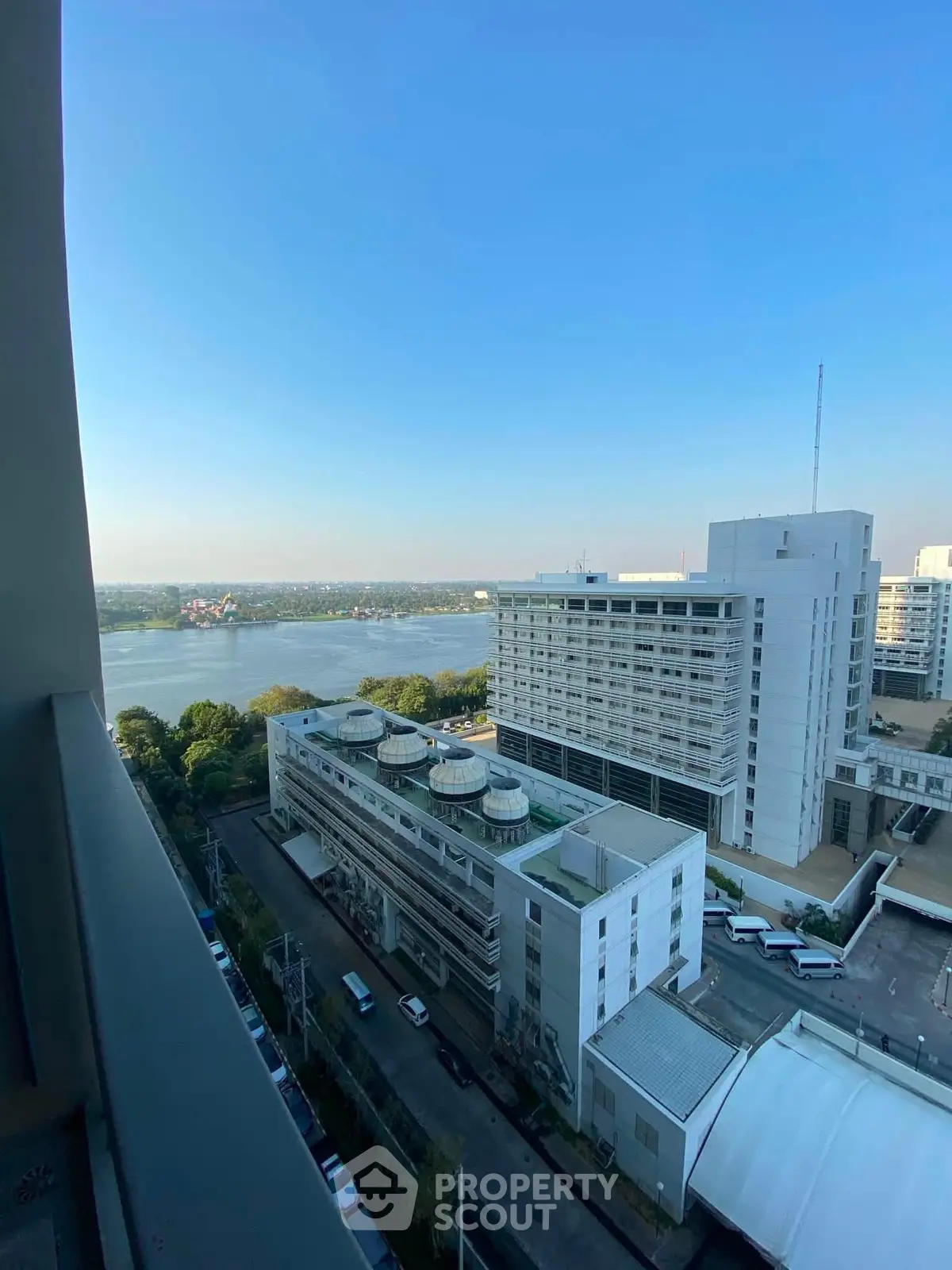 Stunning high-rise view overlooking cityscape and serene water body, perfect for urban living.