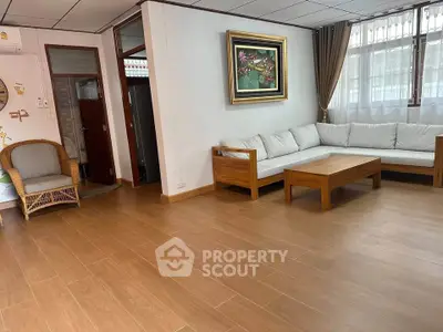 Spacious living room with wooden flooring and modern furniture, perfect for relaxation and entertaining guests.