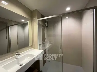 Modern bathroom with sleek shower and elegant sink in contemporary apartment.
