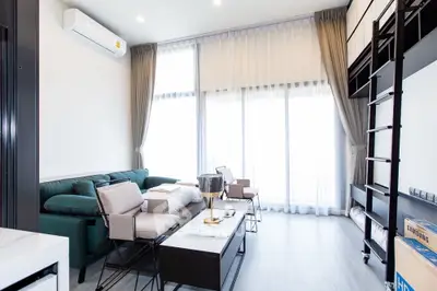 Modern living room with high ceilings and stylish furniture in a bright apartment.