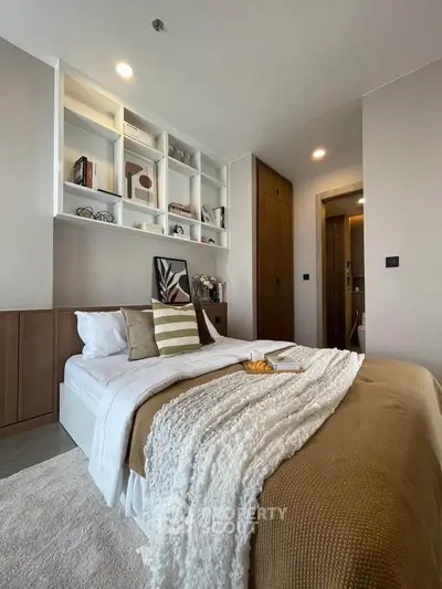 Modern bedroom with stylish decor and built-in shelving, perfect for cozy living.
