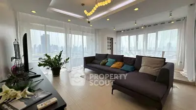 Spacious modern living room with panoramic city views and elegant decor.