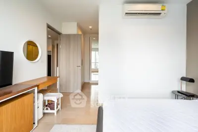 Modern bedroom with minimalist decor and air conditioning in a bright apartment.