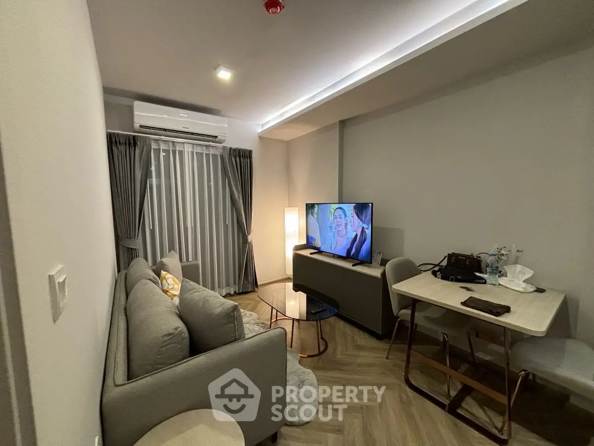 Modern living room with cozy sofa, TV, and dining area in stylish apartment.