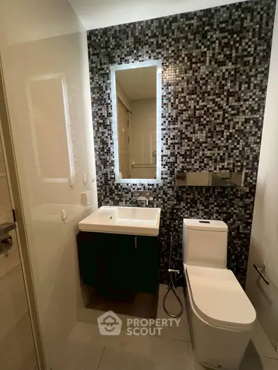 Modern bathroom with mosaic tile wall and sleek fixtures