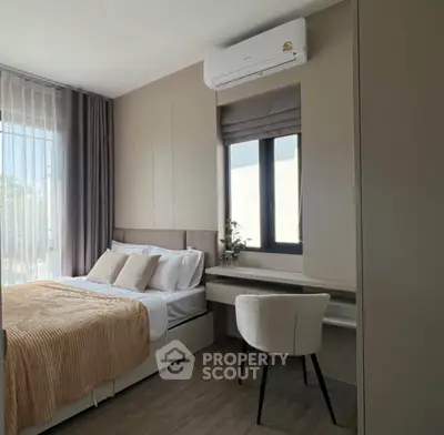 Modern bedroom with stylish decor and natural light, featuring a cozy bed and sleek furniture.