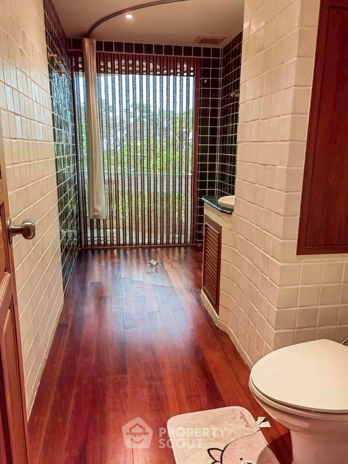 Luxurious bathroom with wooden flooring and large window view
