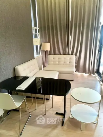 Modern living room with stylish furniture and floor-to-ceiling curtains in a bright apartment.