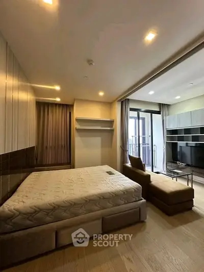 Modern bedroom with balcony access and stylish furnishings in a luxury apartment.