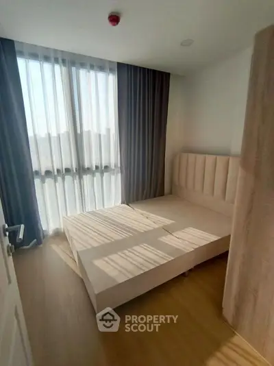 Bright and cozy bedroom with large window and modern furnishings