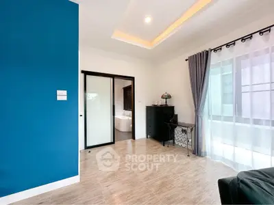 Spacious modern living room with blue accent wall and sliding glass doors